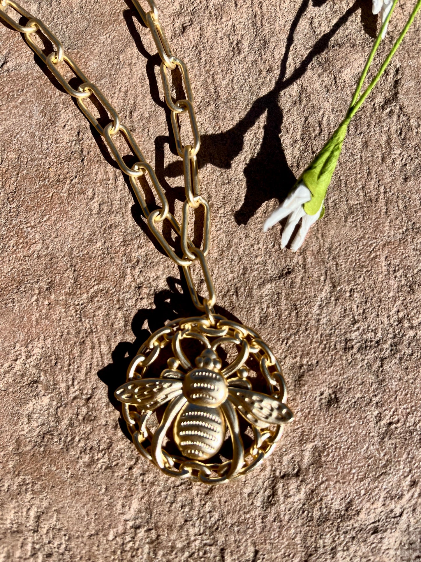 Gold chain with large round bee pendant